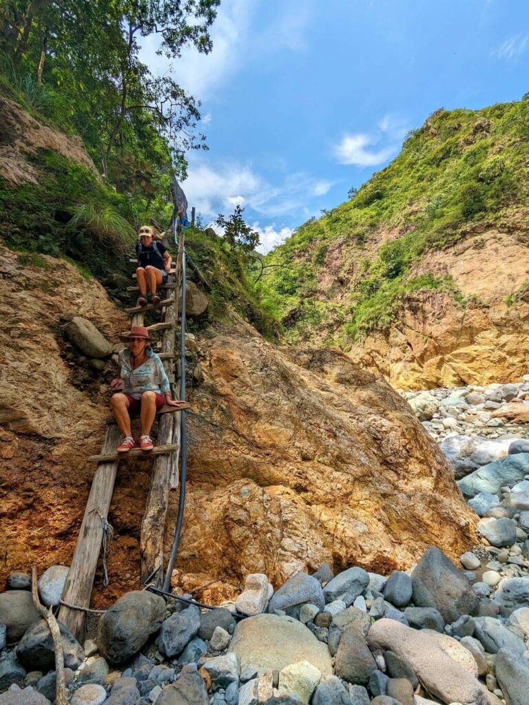 Hikers cautiously descending the provisional ladder towards Aranjuez River Canyon.