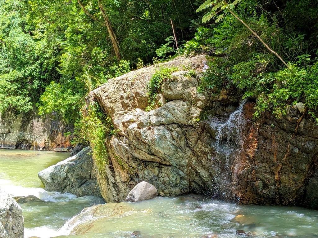 Freshwater stream cascading down a large rock, joining the Aranjuez River during the Boquerones Hike in Bajo Caliente, Puntarenas.