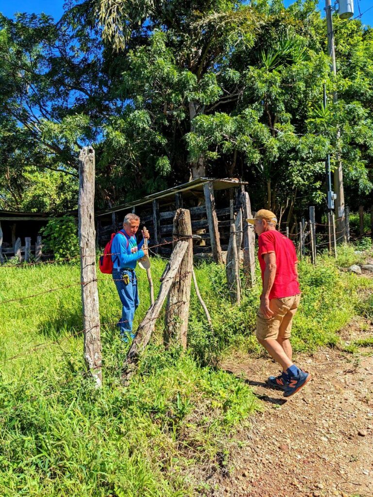 Baquiano assisting hikers by opening the gate to the El Encanto trail entrance.