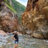 Hiker's feet immersed in the pristine waters of the Aranjuez River within the El Encanto Canyon.
