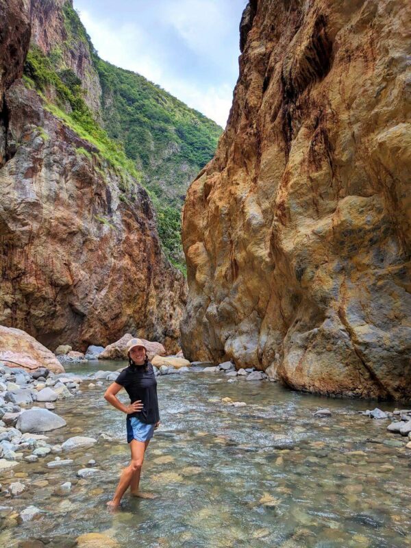 Hiker's feet immersed in the pristine waters of the Aranjuez River within the El Encanto Canyon.