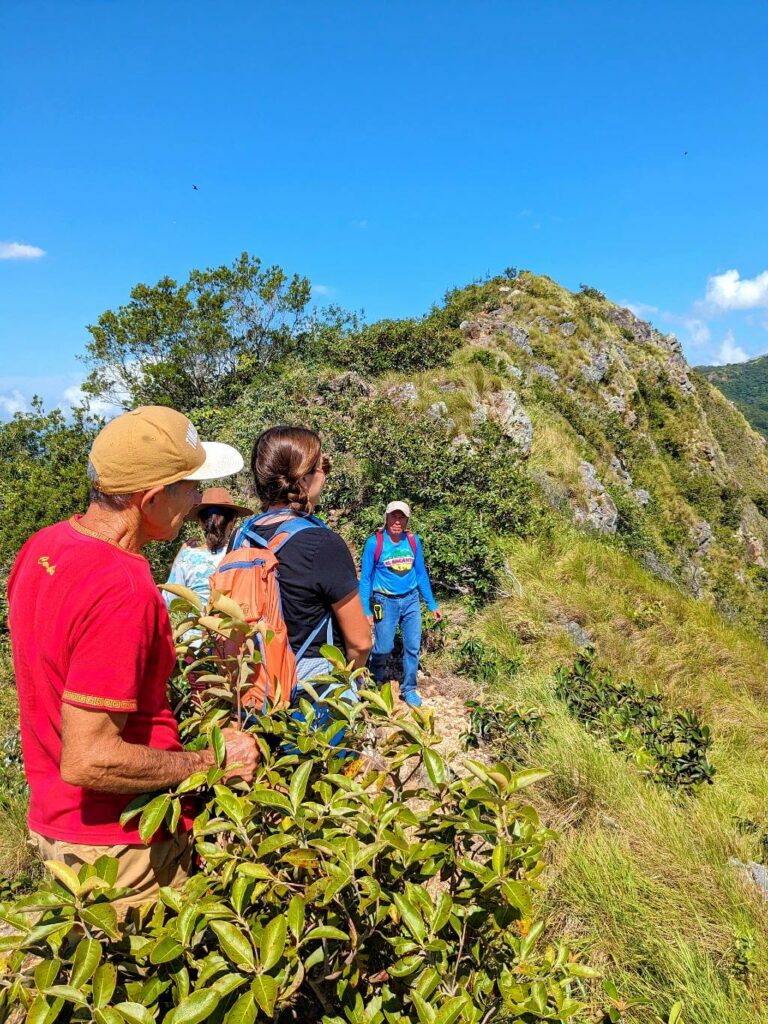 Hikers guided by Genaro, a local baquiano, on the ridge of the El Encanto Trail.