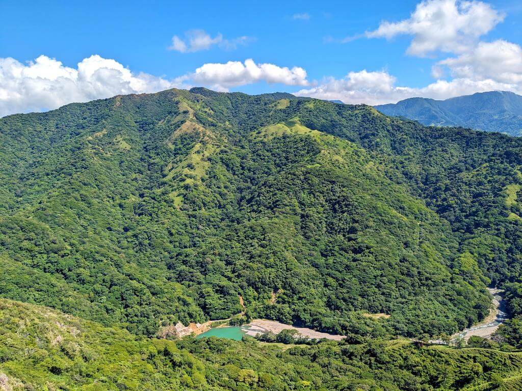 Western vista of the El Encanto Hydroelectric Dam surrounded by a mix of forests and pastures.