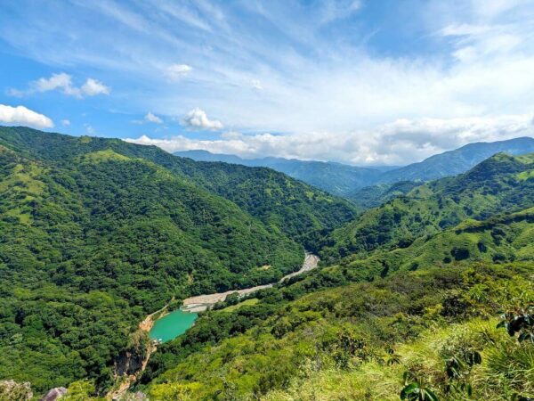 Panoramic view of the Aranjuez River converging with the El Encanto Hydroelectric Dam, nestled amidst verdant mountains.