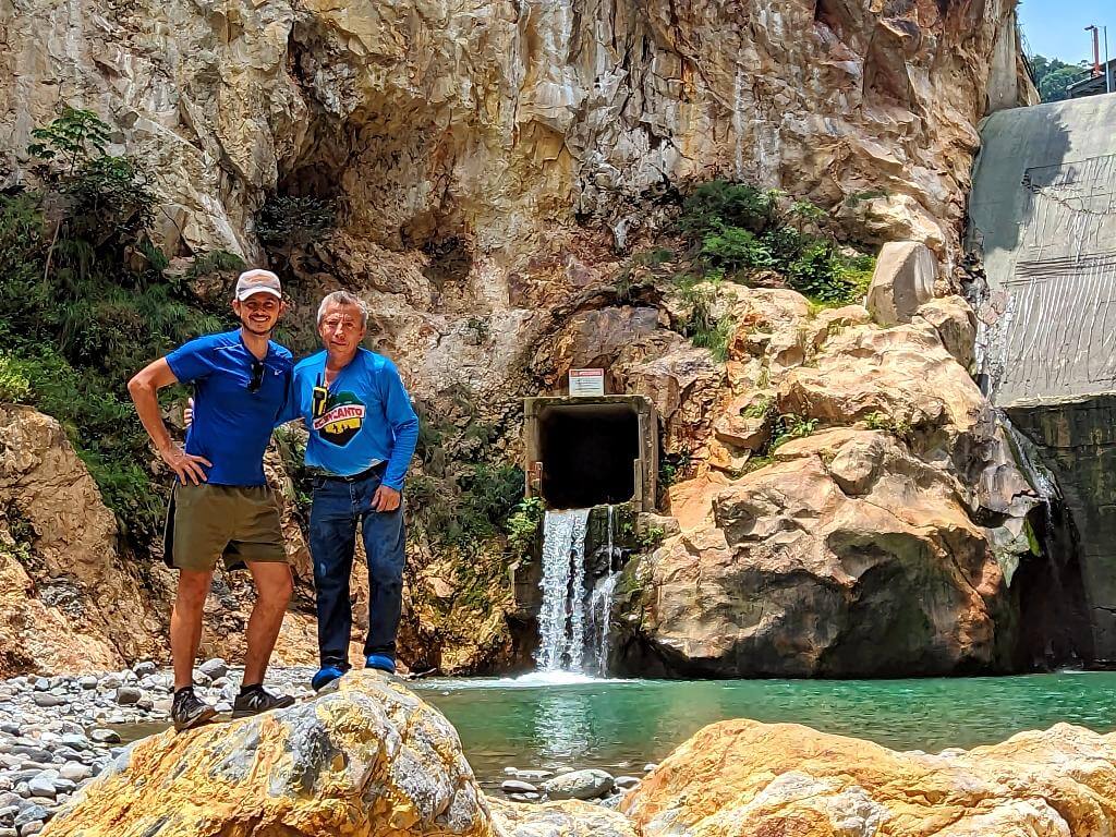 Baquiano and hiker standing in front of the Aranjuez river canyon's hydroelectric dam.