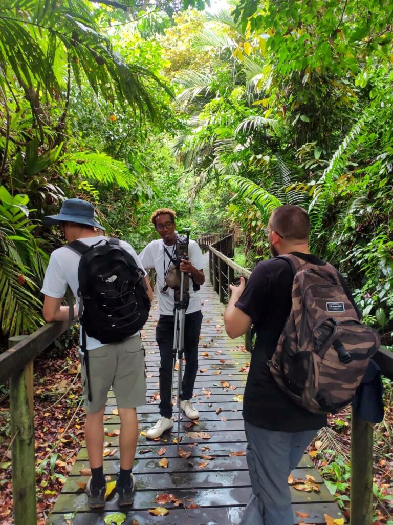 Local tour guide assisting visitors with a telescope at Cahuita National Park.