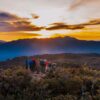 Captivating sunrise from the mountain top of Cerro Ena, nestled among Costa Rica's highest peaks. The image captures the Paramo, towering mountains, the undulating Costa Rican flag, and the radiant ascent of the sun.