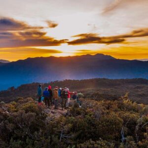 Captivating sunrise from the mountain top of Cerro Ena, nestled among Costa Rica's highest peaks. The image captures the Paramo, towering mountains, the undulating Costa Rican flag, and the radiant ascent of the sun.