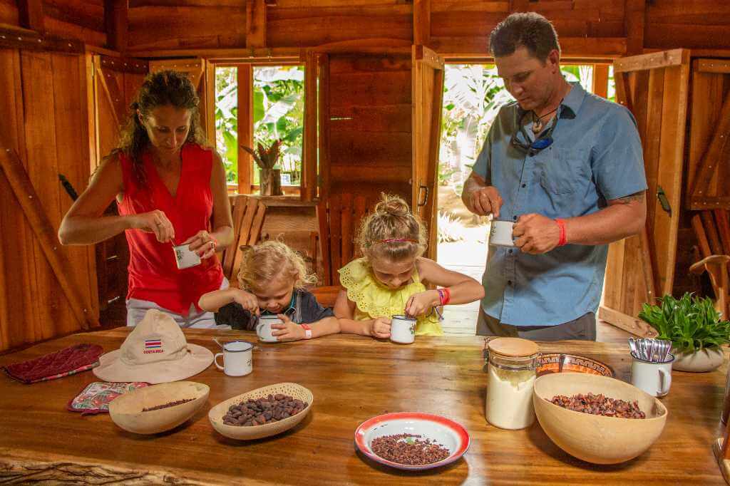 Family on a coffee tour, inspecting seeds and interested in learning about the production process.