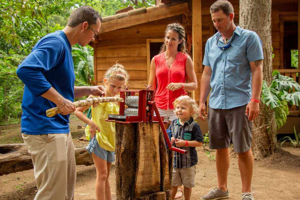 Costa Rican tradition: process of extracting sugarcane juice explained to a family