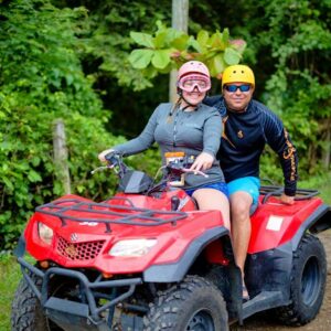 With beaming smiles, this couple enjoys their ATV tour, surrounded by greenery and natural serenity.