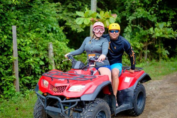 With beaming smiles, this couple enjoys their ATV tour, surrounded by greenery and natural serenity.