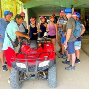 Group of people listening attentively to the directions before starting the ATV tour.