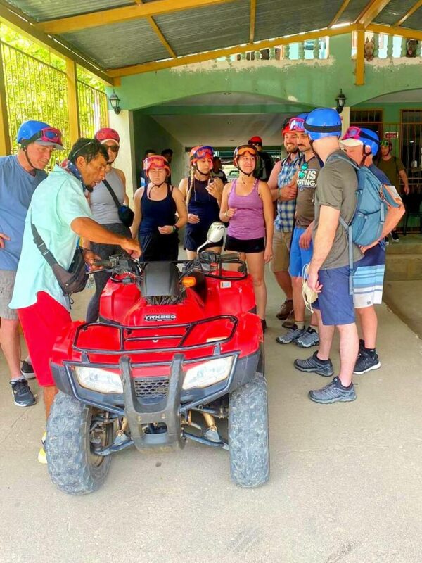 Group of people listening attentively to the directions before starting the ATV tour.