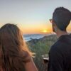 Couple enjoying a glass of wine while watching the sunset over the sea.
