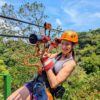 Smiling traveler at the end of the 7th zipline, surrounded by forest at Buena Vista del Rincón, Guanacaste.