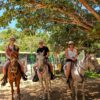 Three travelers posing on horseback before starting a tour at Buena Vista del Rincón in Guanacaste, Costa Rica.