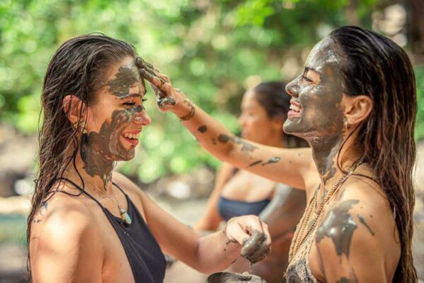 Two girls applying thermal mud to their faces, enjoying a relaxing facial treatment.