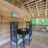 Black wooden table and chairs in a rustic living room with a traditional tile roof.